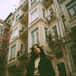 Woman standing in front of old building.