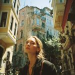 Person walking in a vintage European street scene.