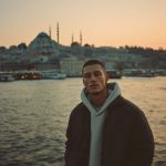 Person by Istanbul waterfront at sunset