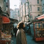 Woman walking through bustling outdoor market.