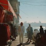 Men in suits by waterfront market stall