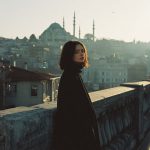 Woman on bridge with mosque in background