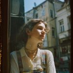 Person gazing out window on sunny day