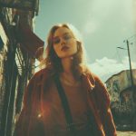 Stylish woman in urban street setting, vibrant sunlight.
