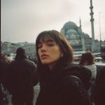 Woman in black coat near mosque