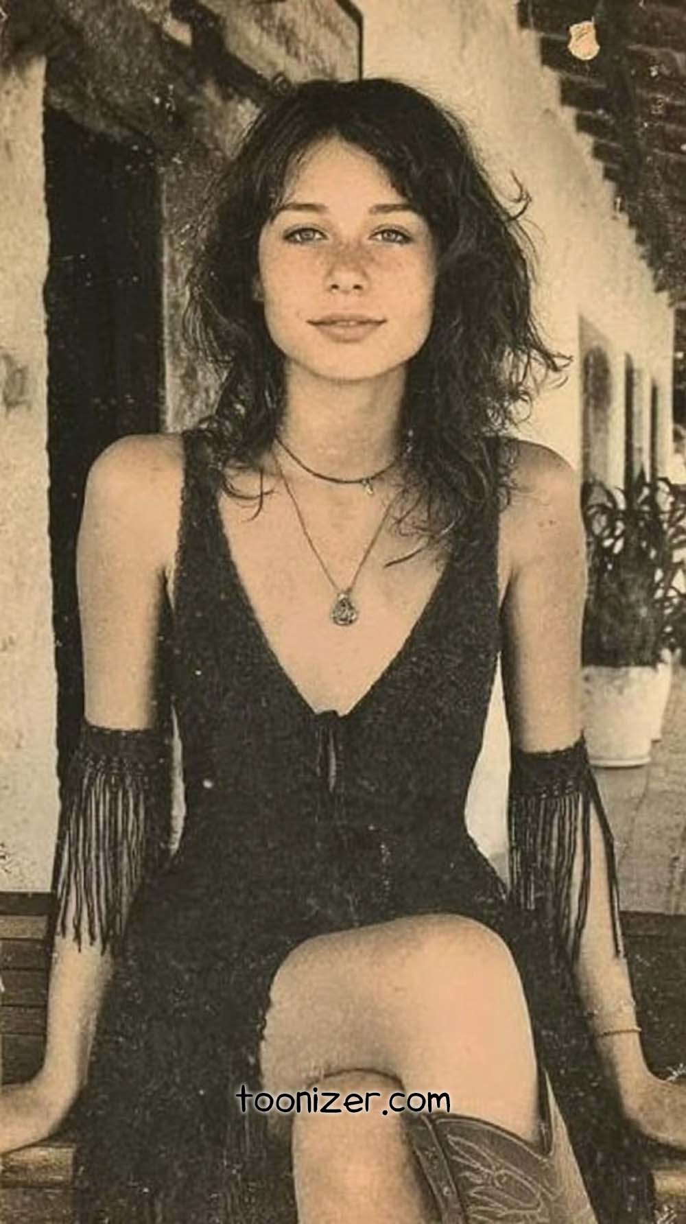 Woman sitting on a wooden bench, smiling.