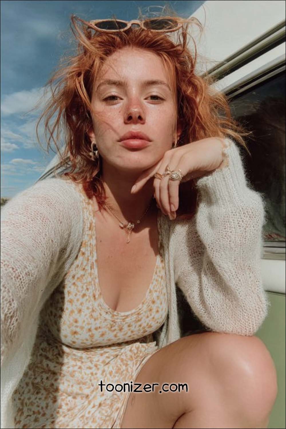 Woman with red hair and freckles, outdoor selfie.