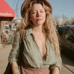 Person in hat and casual attire outdoors.