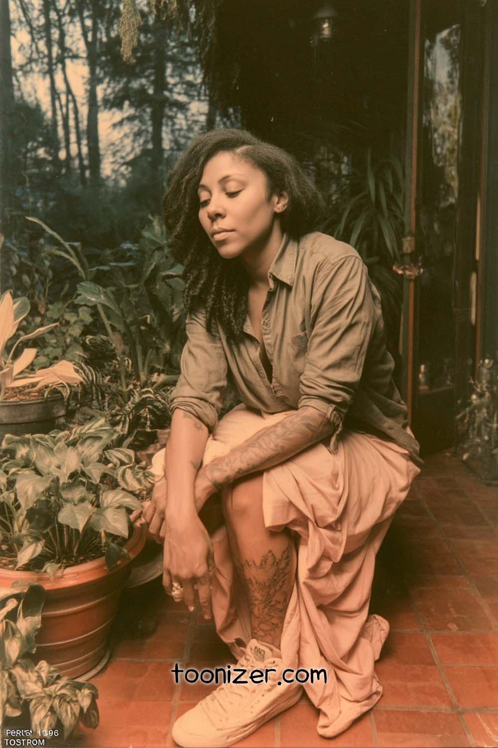 Person sitting in garden with plants around.