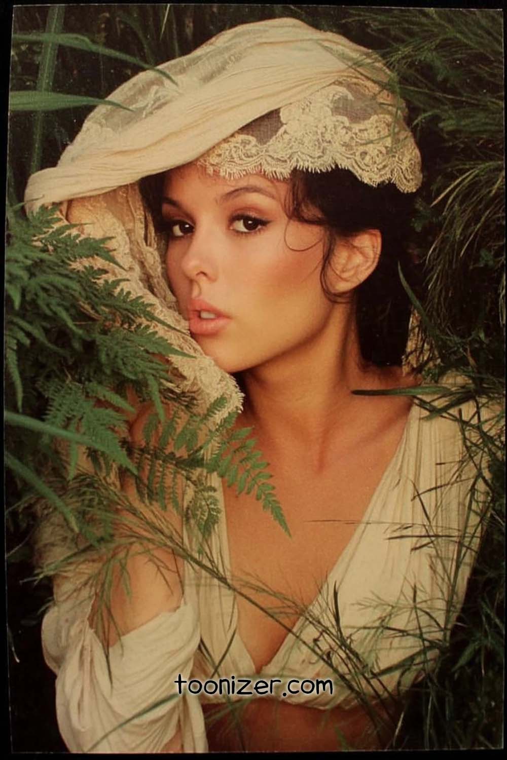 Woman in ferns wearing lace headdress.