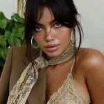 Person in lace top and blazer with plants