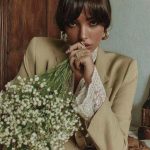 Person holding bouquet of small white flowers.