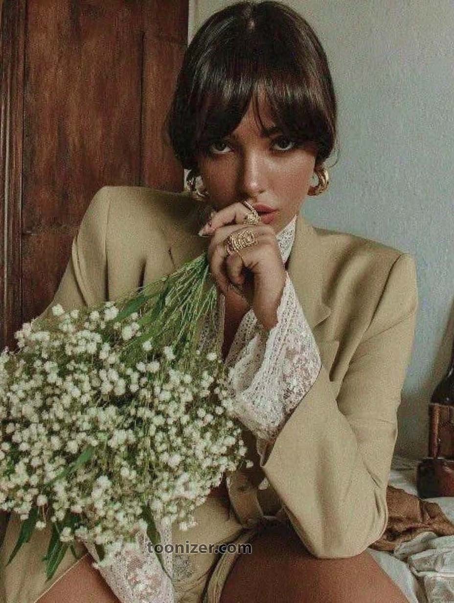 Person holding bouquet of small white flowers.