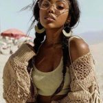 Woman in knit cardigan on a sunny beach.