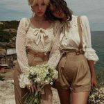 Two women in vintage outfits by the sea.