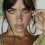 Woman with freckles and hoop earrings.