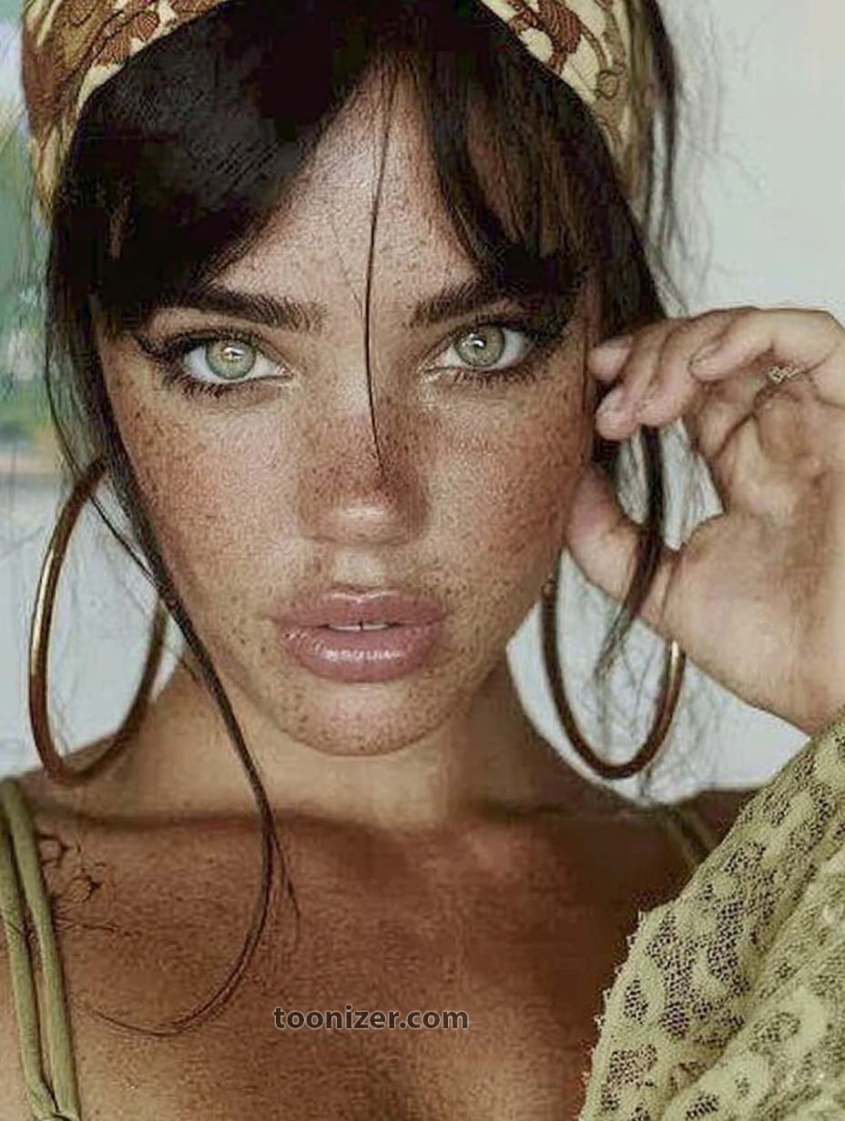 Woman with freckles and hoop earrings.