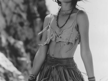 Woman in bohemian attire with sun hat outdoors.
