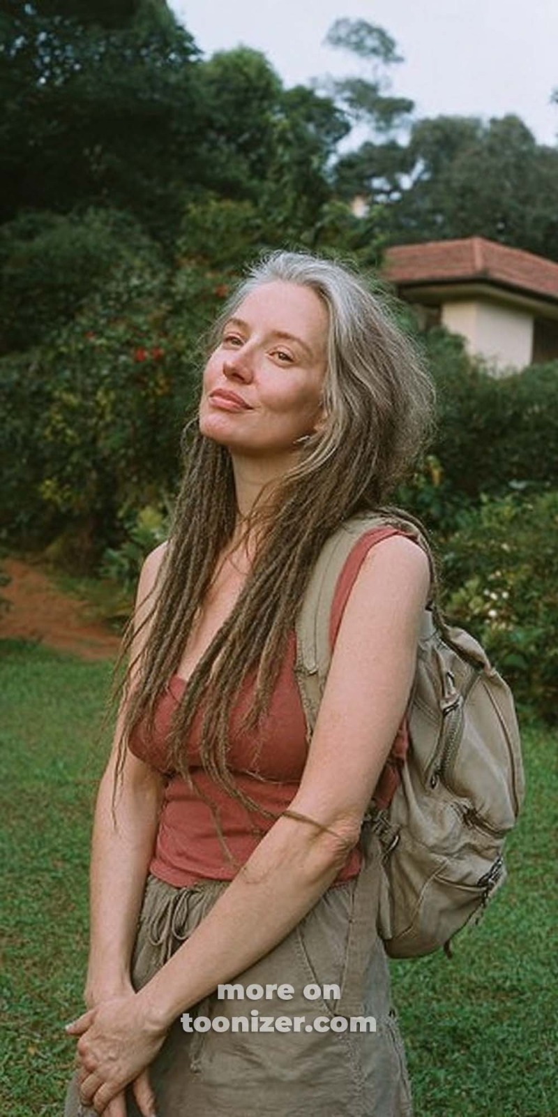Person outdoors with backpack in garden setting.