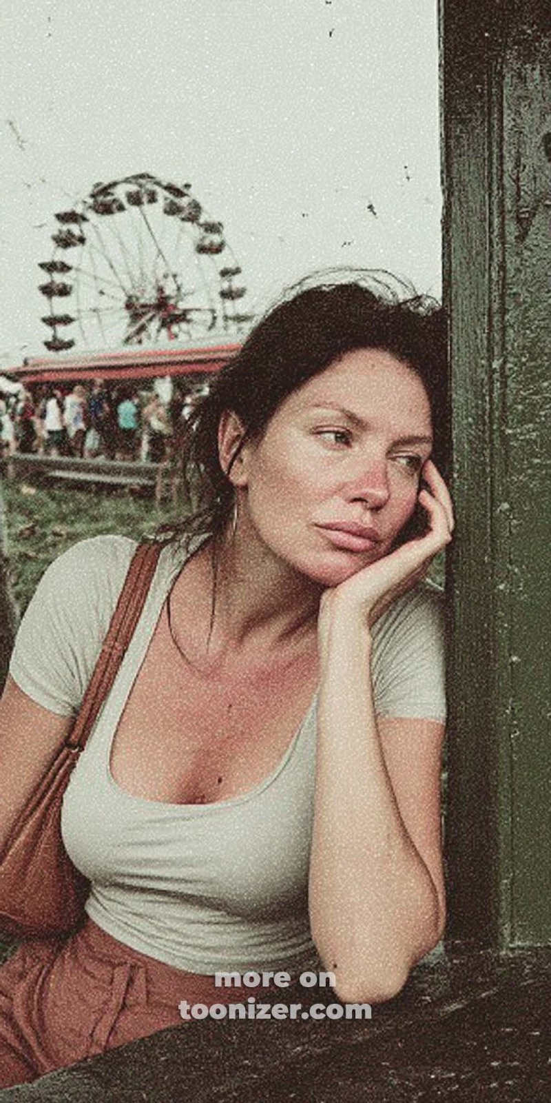 Pensive woman at funfair with Ferris wheel.