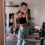 Woman taking mirror selfie in casual outfit