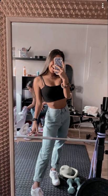 Woman taking mirror selfie in casual outfit