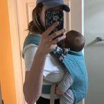 Woman taking selfie with baby in carrier