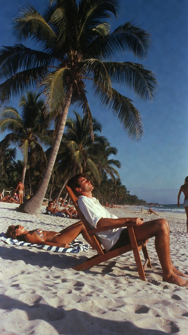 Sunbathers relaxing on a tropical beach.