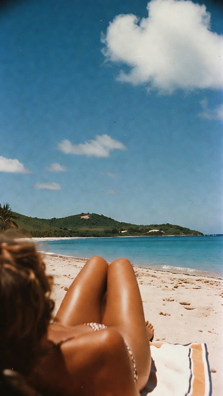 Person relaxing on a sandy beach.