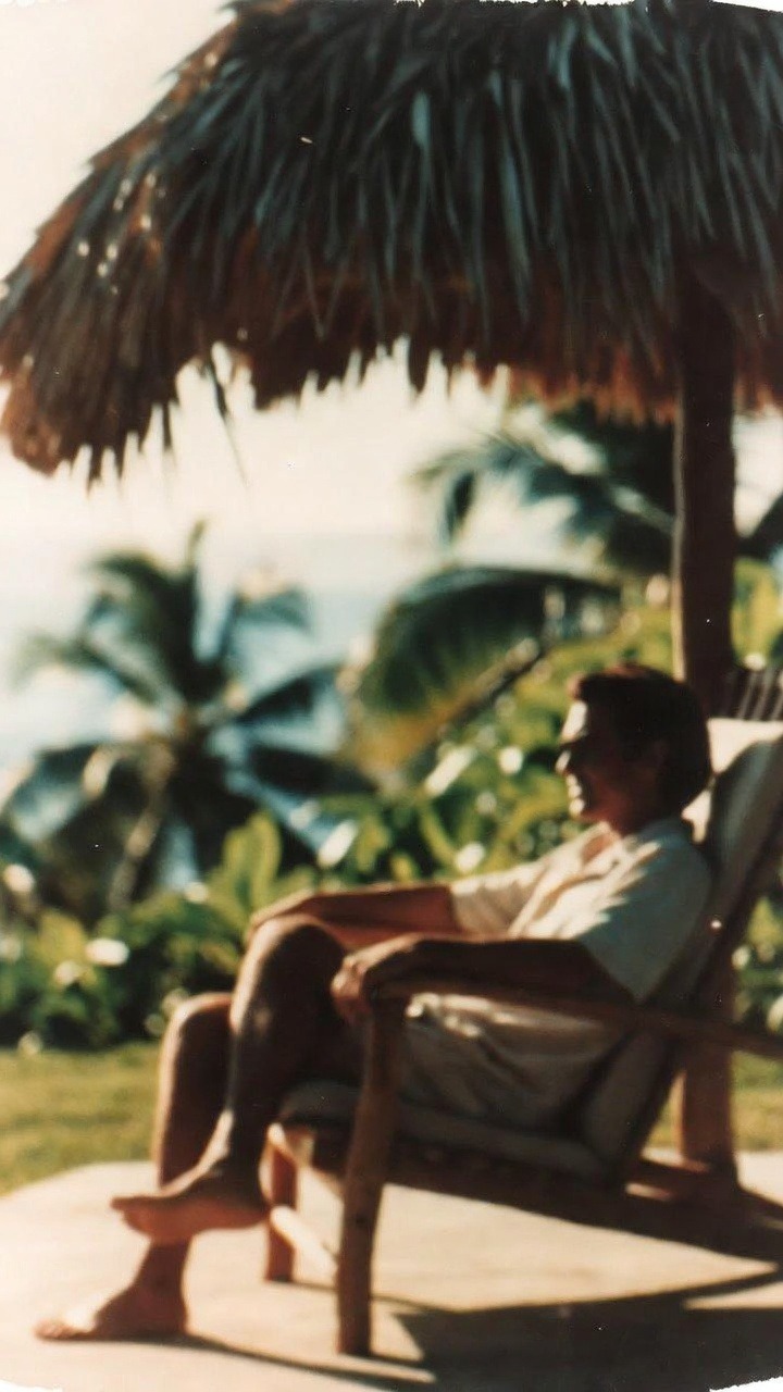 Person relaxing under a straw umbrella.