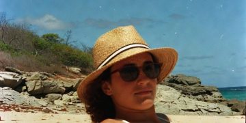 Person relaxing on a sunny beach.