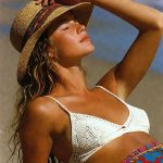 Woman sunbathing on beach wearing straw hat