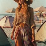 Woman in straw hat walking on beach at sunset