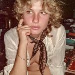 Young person with curly hair and scarf