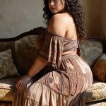 Woman in patterned dress on vintage sofa