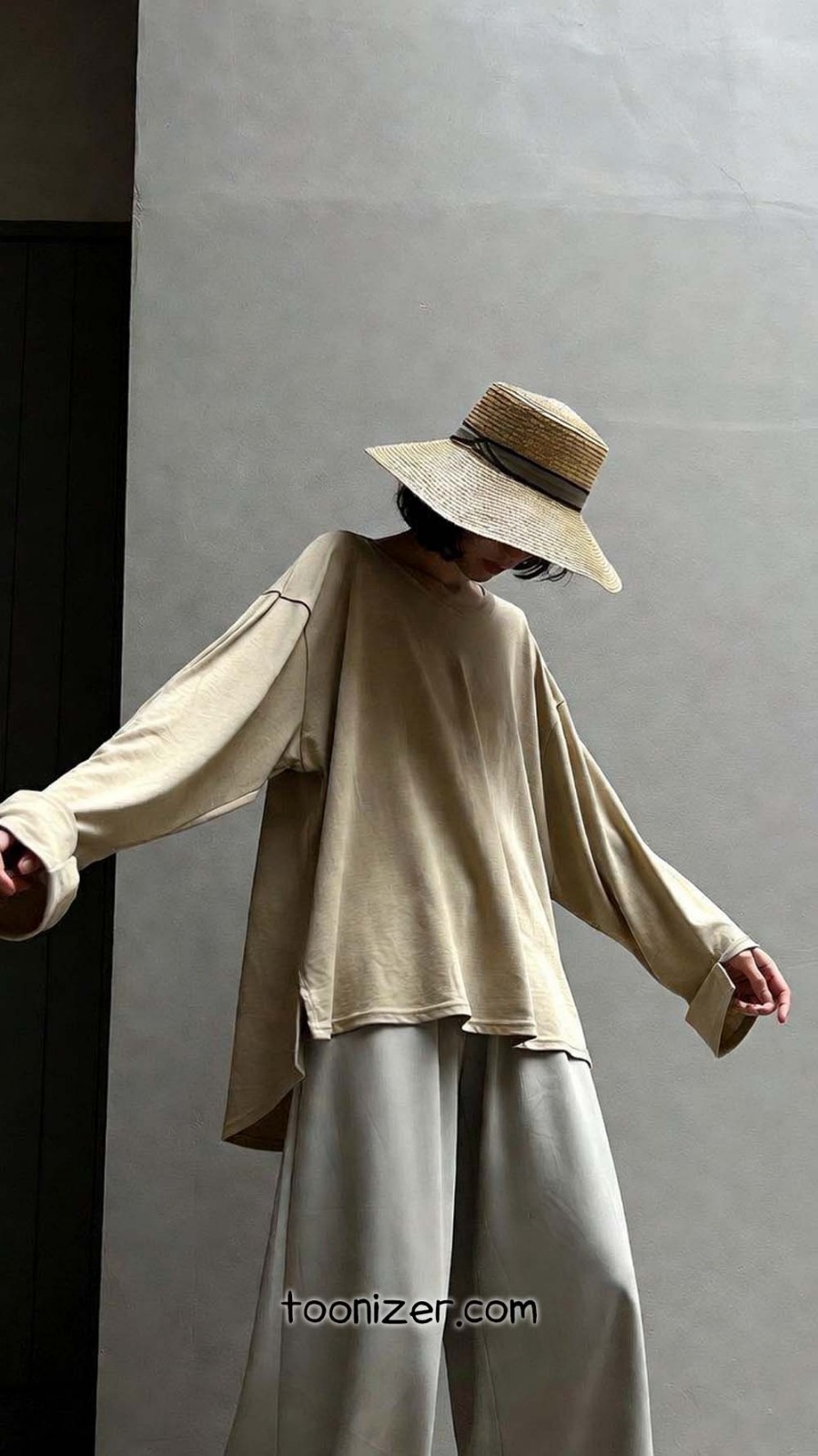 Person in oversized beige outfit with hat
