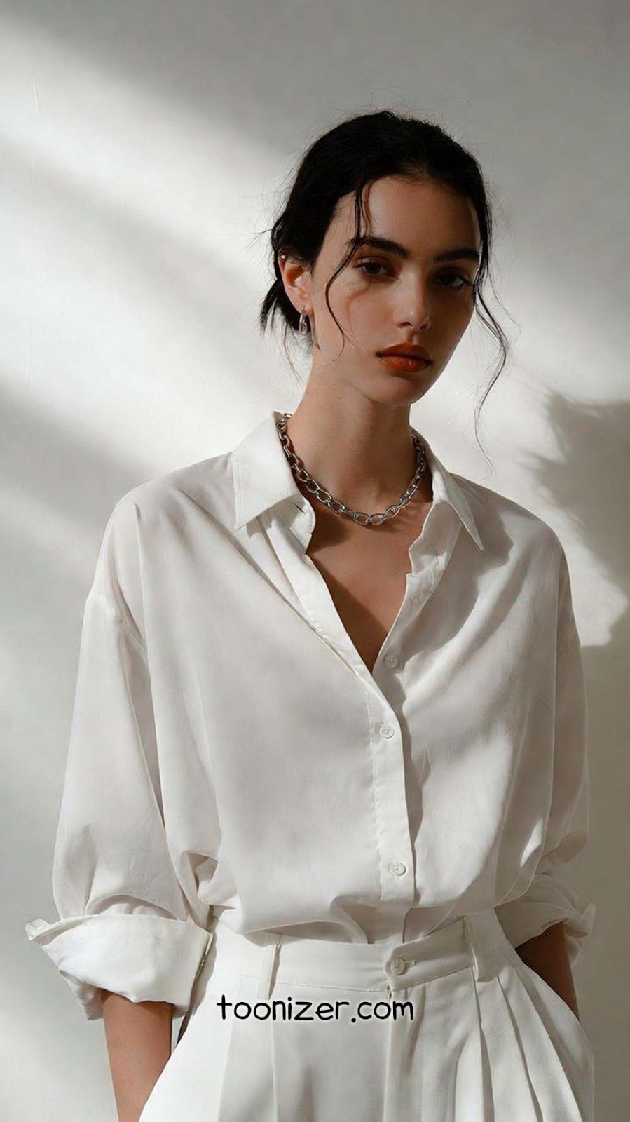 Woman in white shirt and chain necklace