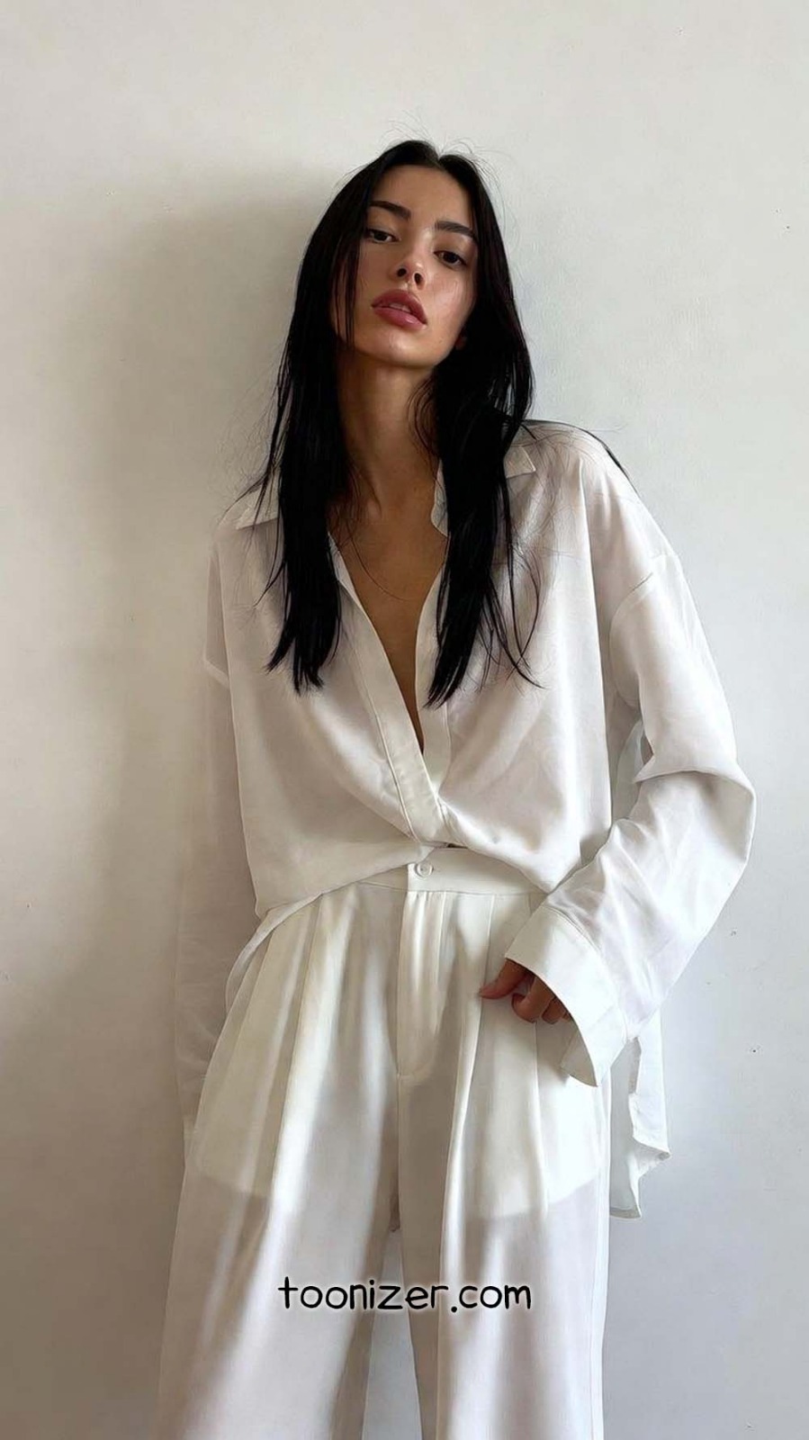 Woman in white outfit against a plain background