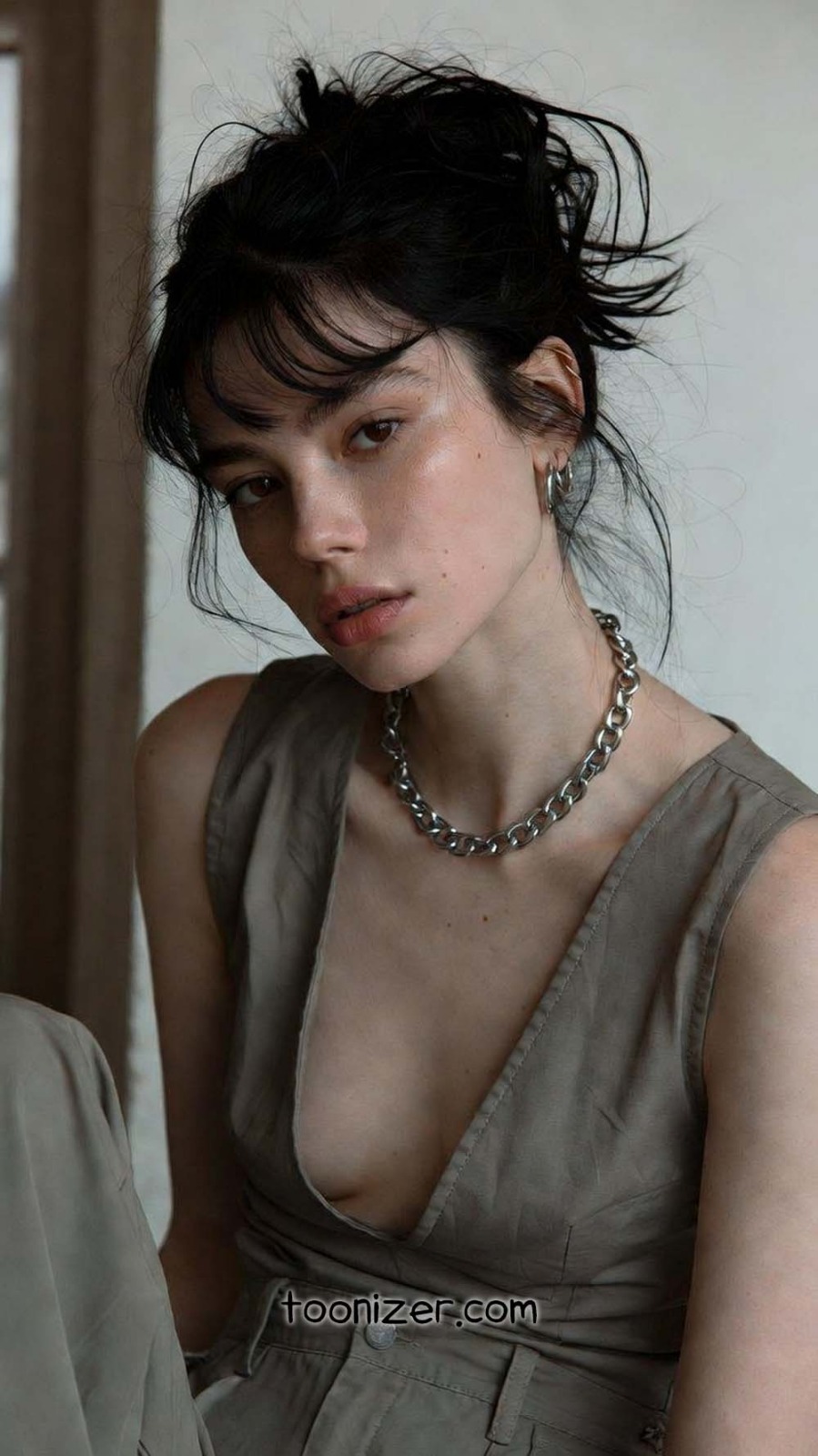 Woman in gray outfit and chain necklace