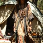 Woman in bohemian dress and sun hat outdoors.