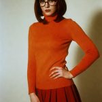 Woman in orange sweater and red skirt