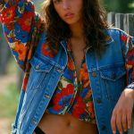 Woman in floral shirt and denim vest