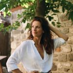 Woman in white shirt by stone wall
