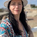 Woman in a hat outdoors.