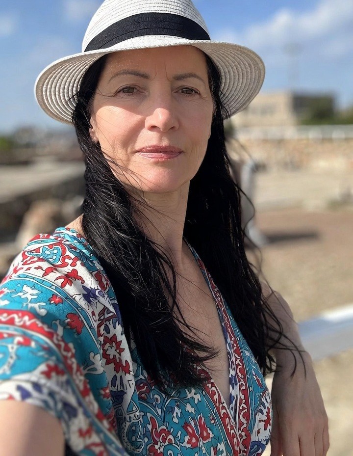 Woman in a hat outdoors.