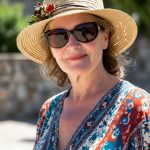 Smiling woman in sunhat and sunglasses.