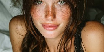 Freckled woman with green eyes in black lace top
