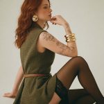 Woman with red hair in green dress posing