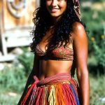 Smiling woman in colorful skirt and headscarf outdoors