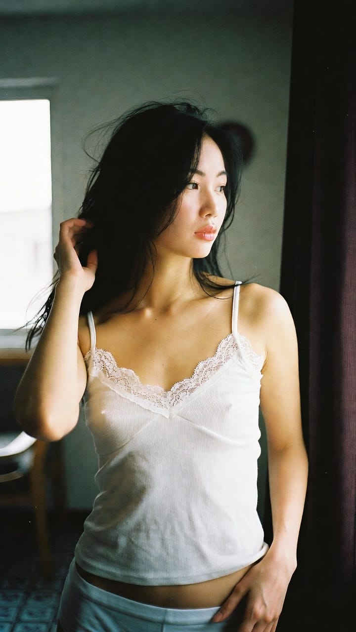 Woman in white lace camisole by window
